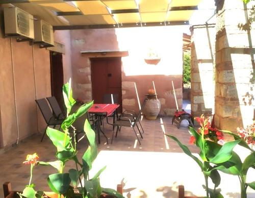 eine Terrasse mit einem Tisch, Stühlen und Pflanzen in der Unterkunft villa archontiko ASKYFOU SFAKIA in Karés