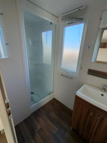une salle de bain avec une douche en verre et un lavabo dans l'établissement Village vacances l'endorph'in, à Déols