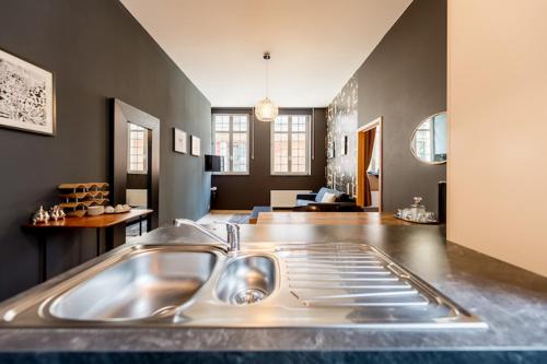 een keuken met een wastafel en een woonkamer bij Smartflats City - Brusselian in Brussel