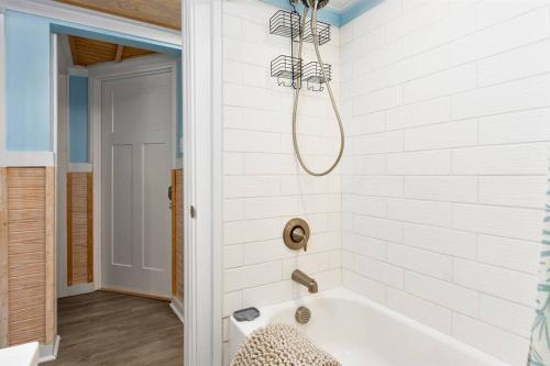 a bath tub in a bathroom with a chandelier at Lil'TipSea on Topsail - Close to the sound and beach! in Topsail Beach