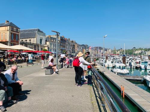 a group of people standing on a pier near a marina at Espace et confort in Auppegard