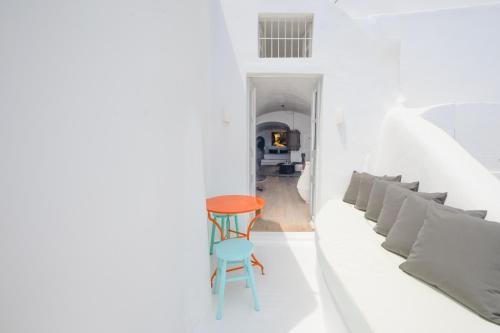 a white room with a table and a chair at Sophia Oia View in Oia