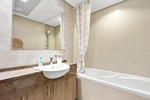 a bathroom with a sink and a bath tub at Silkhaus Luxury 1BDR Near NYU Abu Dhabi in Abu Dhabi