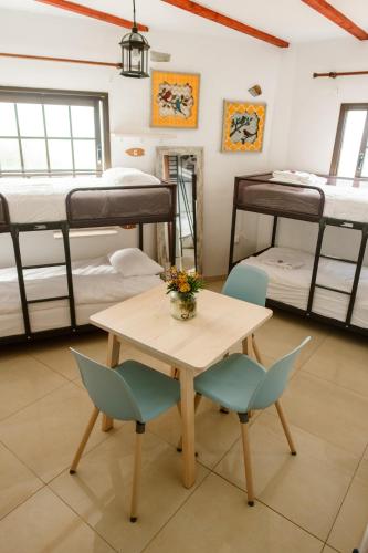 a room with bunk beds and a table and chairs at Casanaga in Almáciga