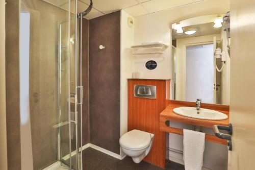 een badkamer met een toilet, een wastafel en een douche bij ACE Hôtel Vendée Saint Hermine in Sainte-Hermine