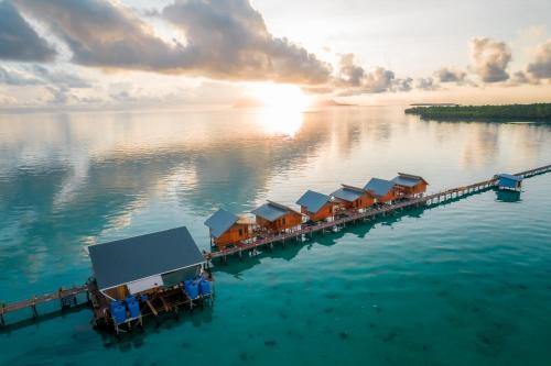 a row of houses on a dock in the water at Larapan Water Village 仙本那乐乐棒水屋 in Semporna