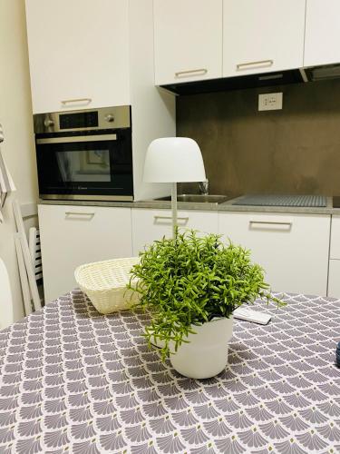 a kitchen with a table with a lamp and a plant at II Sogno nel Vicolo in Pisa