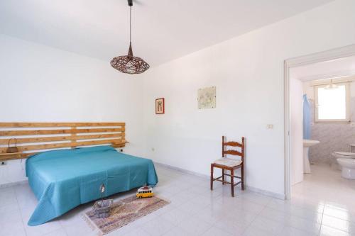 a bedroom with a bed and a chair in it at Villa Ottavia in Torre Lapillo