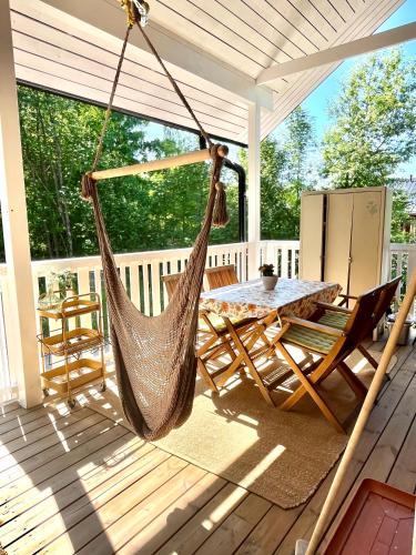 a hammock on a porch with a table and chairs at Villa Tilda in Mathildedal
