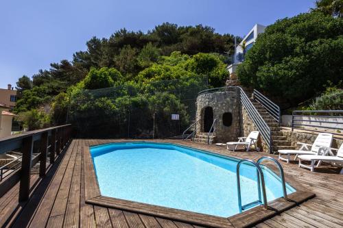 a swimming pool on a wooden deck next to at Paradise bay T3 - by Smarthomes in São Martinho do Porto