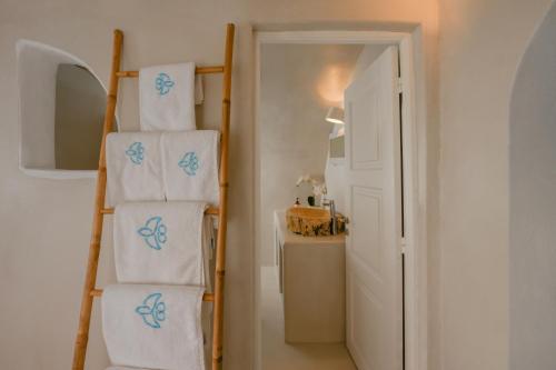 a bathroom with a stack of towels on a ladder at Sophia Oia View in Oia