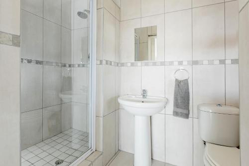 a white bathroom with a toilet and a sink at Garden Route Ilita Lodge in Groot Brak Rivier