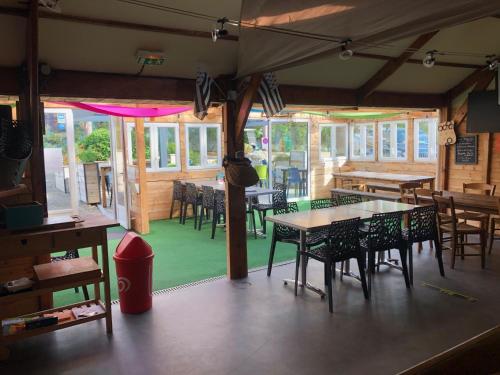 une salle à manger avec des tables et des chaises dans un restaurant dans l'établissement NUIT INSOLITE - Côte de granit rose - Camping Armor Loisirs, à Trébeurden