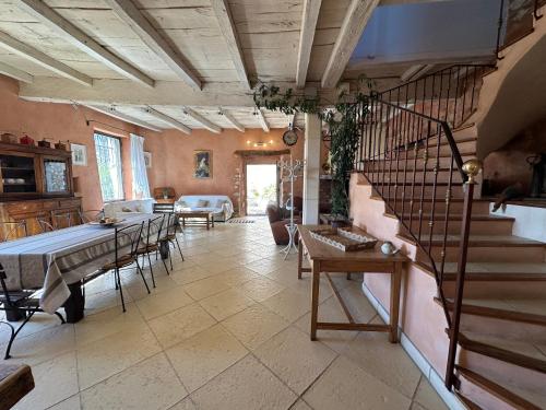 a living room with a staircase and a table and chairs at Le Domaine de Piedmoure, Gîtes et chambres, piscine, terrasses privatives in Sault-de-Vaucluse