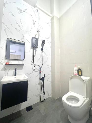a bathroom with a toilet and a tv on the wall at Quayside Cove Homestay - Corner House, Shah Alam Rimbayu Netflix Syok TV BBQ in Shah Alam