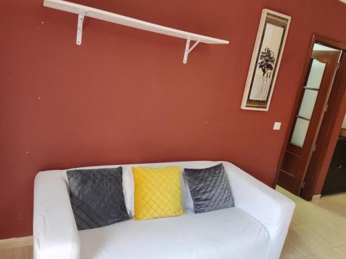 - un canapé blanc avec 3 oreillers colorés dans l'établissement Piso Bajo Santa Ana, à Roquetas de Mar