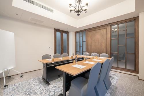 a conference room with a wooden table and chairs at Pranakorn Heritage Hotel in Bangkok