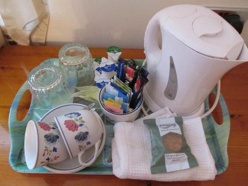 a tea pot sitting on a tray with some food at Albertine ,A warm welcome awaits you ,Offering en-suite room only accommodation,Ideal location for Solent Way ,High Street ,Isle of Wight ,New Forest in Lymington