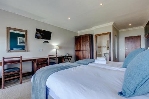a large bedroom with two beds and a desk at Garden Route Ilita Lodge in Groot Brak Rivier