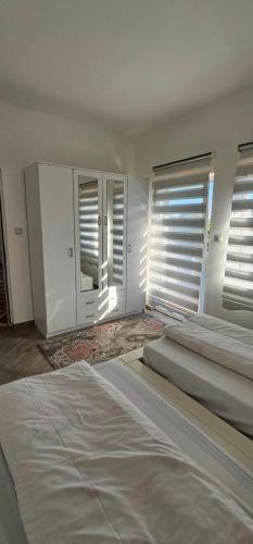 a bedroom with two beds and windows with blinds at Aphrodite Apartment in Lastva