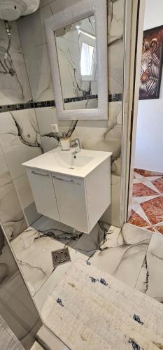 a bathroom with a sink and a mirror at Aphrodite Apartment in Lastva