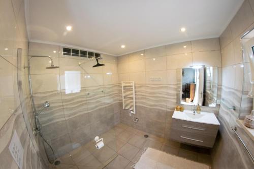 un bagno con doccia e lavandino di Quinta Alcarias a Santa Catarina da Fonte do Bispo