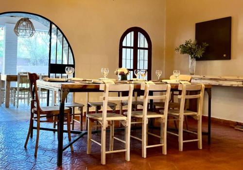 una sala da pranzo con un grande tavolo e sedie di Casa Flora, cálida casa en el corazón de Chacras de Coria a Ciudad Lujan de Cuyo