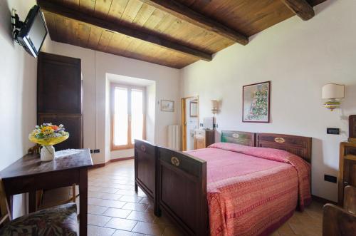 a bedroom with a large bed with a red bedspread at Agriturismo Ca'de'Gatti in Faenza