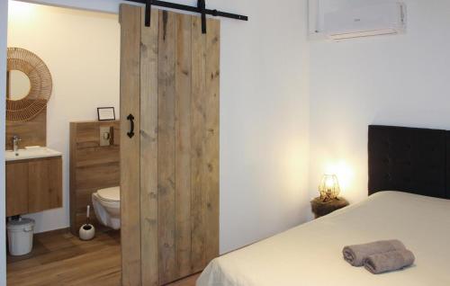 グリニャンにあるLa Bastideのバスルーム(ベッド1台付)、木製のスライドドアが備わります。