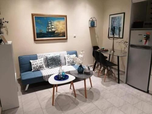 een woonkamer met een blauwe bank en een tafel bij Nelly's Private Resindence in Chania