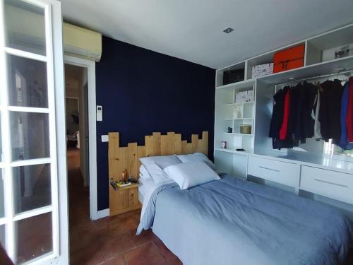 une chambre avec un lit et un mur bleu dans l'établissement Maison piscine proche St Tropez, à Gassin