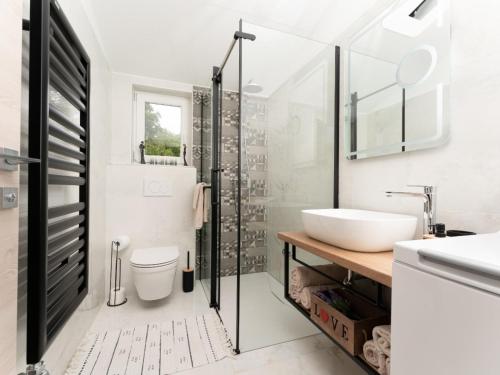 een witte badkamer met een wastafel en een douche bij Apartment Gaia in Labin