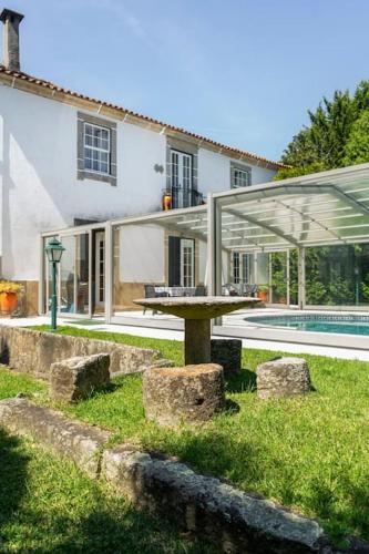 a picnic table in front of a house with a pool at Our Lady of Mercy Villa in Ermesinde