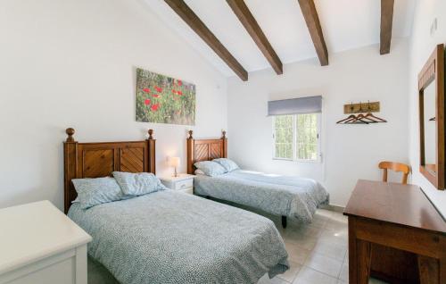 a bedroom with two beds and a table in it at Nice Home In La Puebla De Los Infan in La Puebla de los Infantes