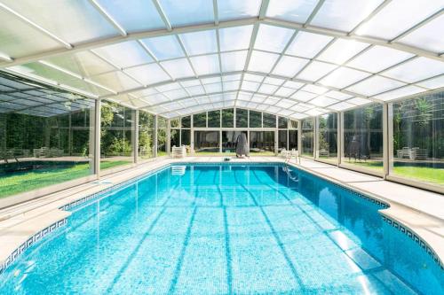 an indoor swimming pool with a glass ceiling at Our Lady of Mercy Villa in Ermesinde