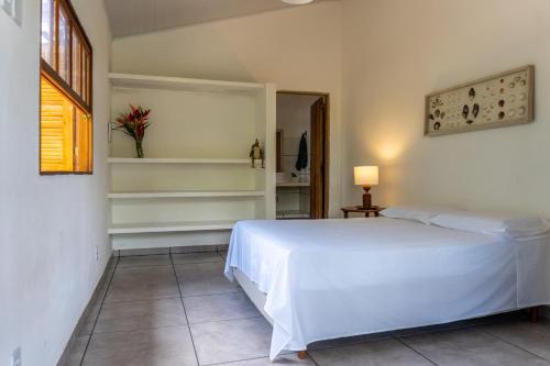 a bedroom with a white bed in a room at Apartamento pé na areia em Algodões, Península de Maraú Bahia in Marau