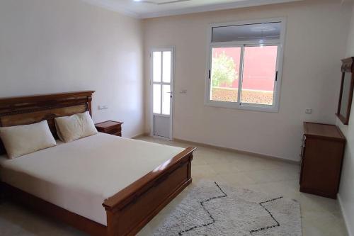 a bedroom with a large bed and a window at Logement familial 3 in Selouane