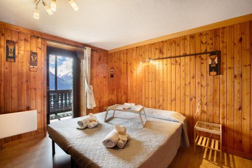 a bedroom with two beds in a room with wooden walls at Agriturismo Les Ecureuils in Saint-Pierre