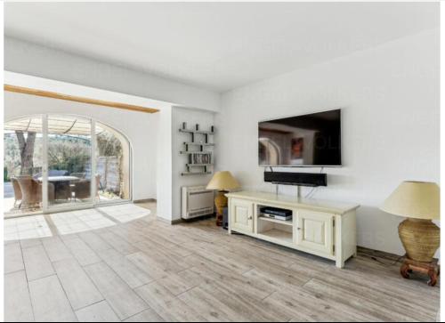 - un salon blanc avec une télévision et une table dans l'établissement SAINT TROPEZ-Golf view, à Saint-Tropez