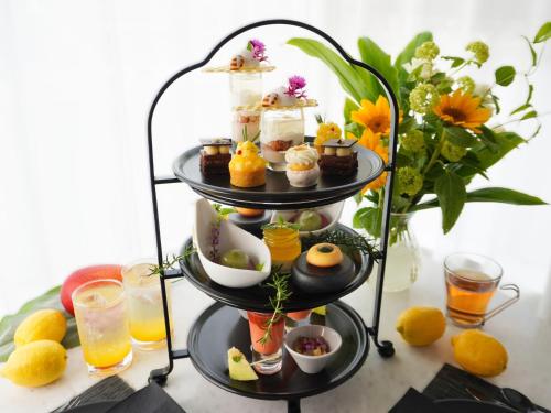 a three tiered display of pastries and drinks on a table at The OneFive Villa Fukuoka in Fukuoka