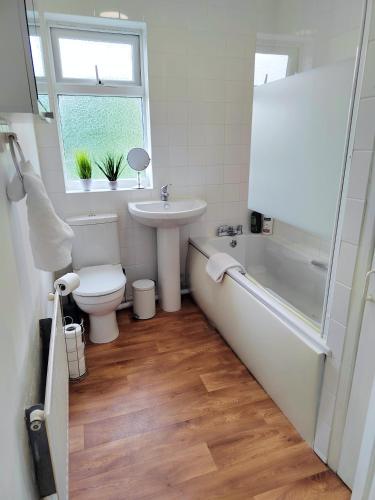 a bathroom with a toilet and a sink and a bath tub at Epicsa - Corporate & Family Stay in 3 Bedroom House with Garden, FREE parking in Cambridge