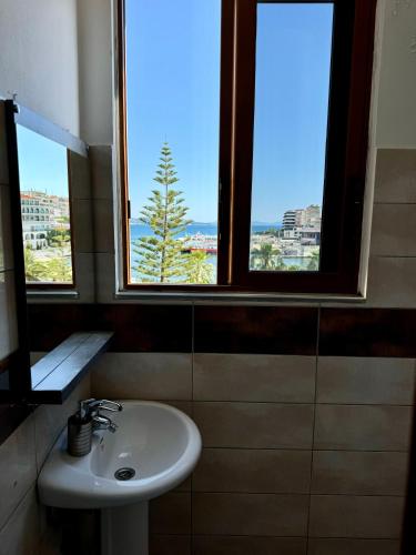 a bathroom with a sink and two windows at Hotel Cakalli in Sarandë