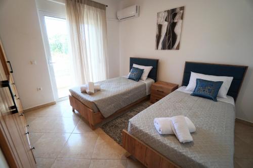 a bedroom with two beds and a window at Anna's Apartments in Kremasti