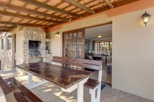 a wooden bench in a room with a fireplace at Garden Route Ilita Lodge in Groot Brak Rivier