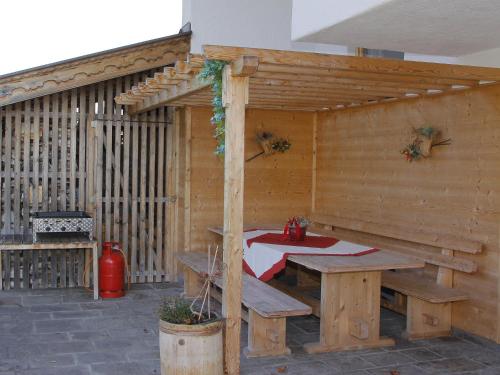 a wooden pavilion with a table and a picnic table at Apartment Gasteighof-6 by Interhome in Fügen