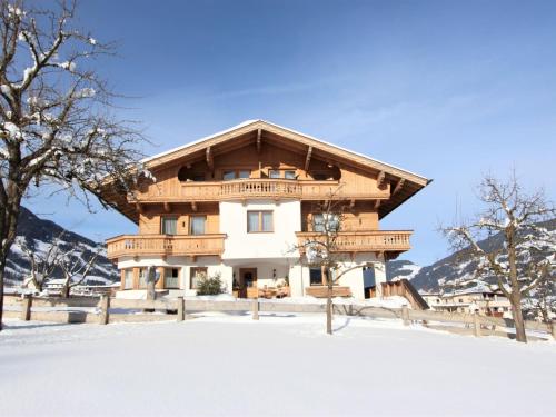 a large wooden house in the snow at Apartment Gasteighof-6 by Interhome in Fügen