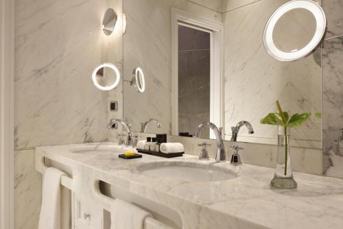 a white bathroom with a sink and a mirror at Hotel Splendide Royal - The Leading Hotels of the World in Rome
