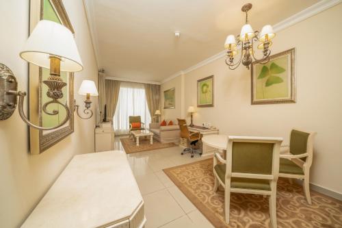 a living room with a table and chairs at Mercure Dubai Barsha Heights Hotel Suites And Apartments in Dubai