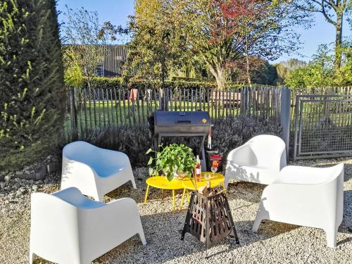 eine Terrasse mit weißen Stühlen und einem Grill in der Unterkunft Holiday Home Gîte L'Archipel by Interhome in Ellezelles