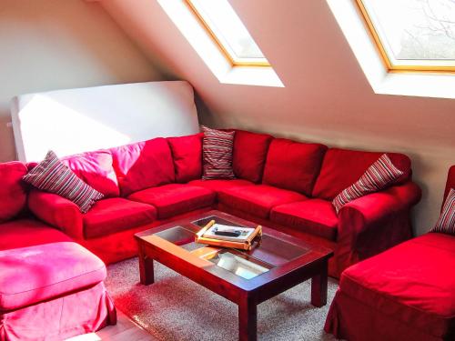 EllezellesにあるHoliday Home Gîte L'Archipel by Interhomeのリビングルーム(赤いソファ、テーブル付)